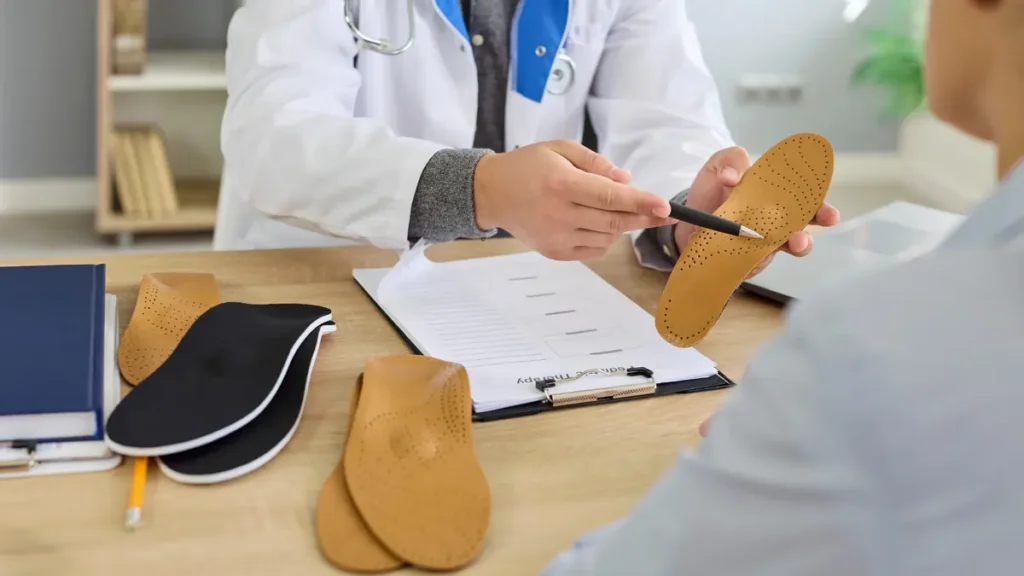 Dr. Laha of Kansas City Foot Specialists discussing custom orthotic shoe inserts with a patient.